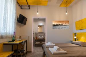 een kamer met 2 bedden en een badkamer met een wastafel bij B&B L'Officina di Apollo in Mondello