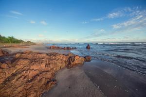 a beach with rocks in the sand and water at C Beyond Nilaveli in Nilaveli