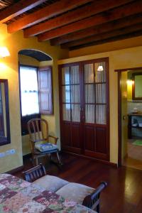 um quarto com uma cama, uma cadeira e portas em Casa Rural El Hondillo em Valverde