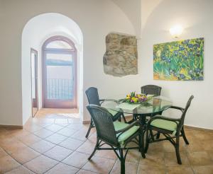 a dining room with a glass table and chairs at Casa Del Lavatoio in Cefalù