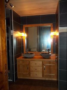 a bathroom with two sinks and a mirror at Ouxis in Orlu