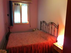 a bedroom with a bed with a red bedspread and a window at Villa Gina in Avola