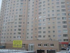 モスクワにあるNa Kirovogradskoy Apartmentの目の前に黄色の看板が立つ大きな建物