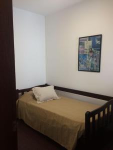 1 cama en una habitación con una foto en la pared en Patio del Bastion 07, en Colonia del Sacramento