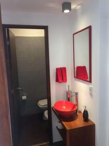 baño con lavabo rojo y aseo en Patio del Bastion 07, en Colonia del Sacramento
