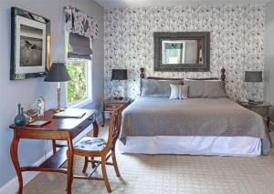 Un dormitorio con una cama y un escritorio con sidx sidx sidx sidx en Shadow Lawn Inn, en Rothesay