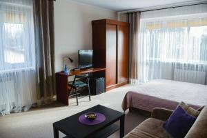 a hotel room with a bed and a desk with a computer at Villa Green in Oświęcim