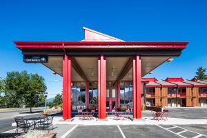 a building with red columns and tables in a parking lot at Red Lion Inn & Suites Missoula in Missoula