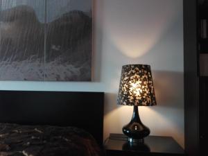 a lamp sitting on a table next to a bed at Apartamento Montes e Vales no Centro in Vila Real