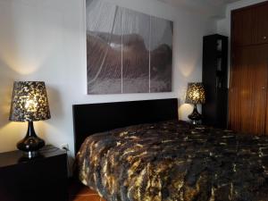 a bedroom with a bed and two lamps on tables at Apartamento Montes e Vales no Centro in Vila Real