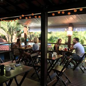 un grupo de personas sentadas en mesas en un restaurante en Pousada Paloma en Ilha Grande