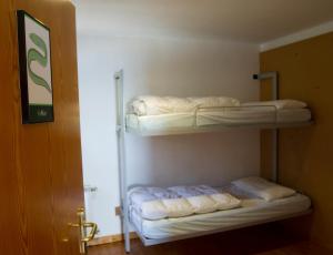 two bunk beds in a small room with a door at Albergue Montes de Anaga in El Bailadero