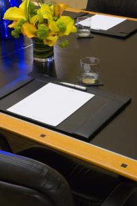 a table with a vase of yellow flowers on it at Millennium Hotel Broadway Times Square in New York