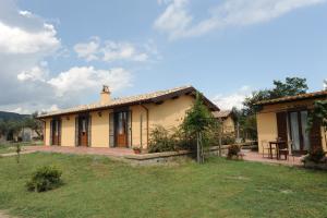mały żółty dom ze stołem na dziedzińcu w obiekcie Agriturismo "La Fraschetta" w mieście Bolsena