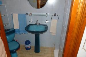 y baño con lavabo azul y aseo. en "Le Pigeonnier" chambre d'hôte, en Piégros-la-Clastre