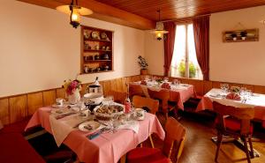 jadalnia ze stołami i różowymi obrusami w obiekcie Hotel Beausite Budget w mieście Interlaken
