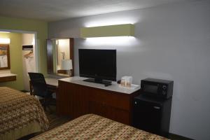 een hotelkamer met een slaapkamer met 2 bedden en een flatscreen-tv bij Jameson Inn Winder in Winder