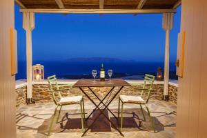 a table and chairs on a patio with a view of the ocean at Vathisthea in Kithnos