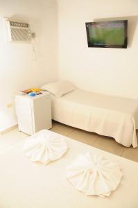 ein Schlafzimmer mit einem Bett und zwei Teppichen auf dem Boden in der Unterkunft Hostal de la Costa in Villa Carlos Paz