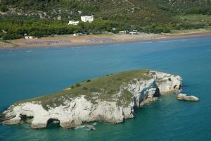 an island in the water next to a beach at Hotel Portonuovo in Vieste