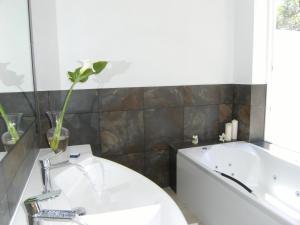 a bathroom with a white sink and a bath tub at Hotel Rural Can Maries in Puerto de San Miguel