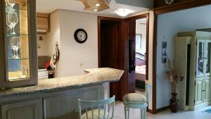 eine Küche mit einer Theke und einer Uhr an der Wand in der Unterkunft Apartamento Monte Bianco in Gramado + 12 Fotos