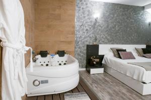 サン・ラファエルにあるHabitaciones Premium Finca la Casonaのバスルーム(ベッド1台付)、ベッドルームの隣にバスタブが備わります。