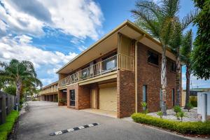 un edificio de ladrillo con balcón en una calle en Allambi Holiday Apartments, en Lakes Entrance