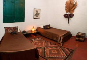 1 dormitorio con 2 camas y 1 alfombra en una habitación en Casa Colonial em Praia Paradisíaca, en Barra de São João