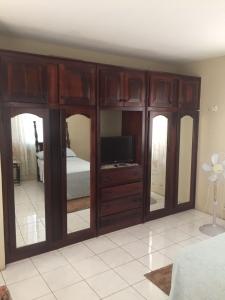 a bedroom with a large wooden entertainment center with a television at Griffiths Home in White Hill