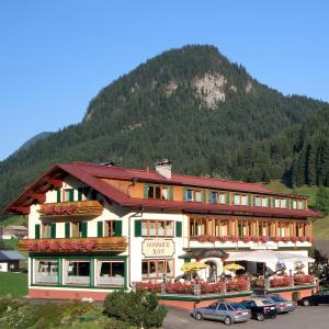 um grande edifício em frente a uma montanha em Hotel - Restaurant Gosauerhof em Gosau