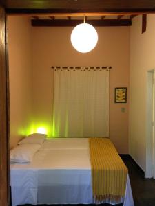 a bedroom with a bed with a light on it at Suite Praia da Feiticeira in Ilhabela