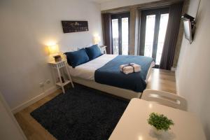 Dormitorio pequeño con cama con almohadas azules en Historical Porto Studios, en Oporto