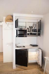 una cocina con electrodomésticos en blanco y negro en una habitación en Historical Porto Studios, en Oporto