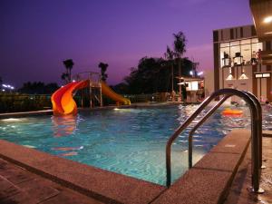 uma piscina à noite com um escorrega em Trat City Hotel em Trat