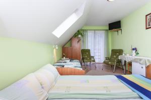 a room with two beds and a table and chairs at Villa Ula in Pobierowo