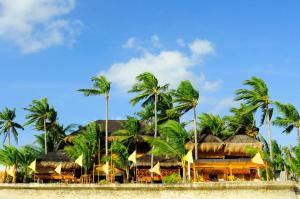 un complejo en la playa con palmeras en The Coral Blue Oriental Beach Villas and Suites en Bantayan Island
