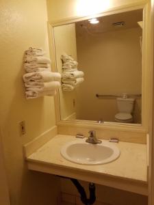 uma casa de banho com um lavatório, um espelho e um WC. em Travel Time Motel em San Diego