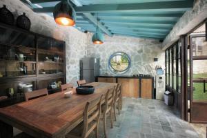 a dining room with a large wooden table and chairs at Villa Sunset Jogjakarta in Yogyakarta