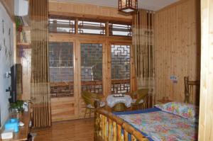 een slaapkamer met een bed en een groot raam bij Yangjiajie Inn in Zhangjiajie