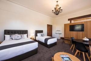 a hotel room with two beds and a table at The Parkview Boutique hotel in Mudgee