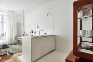a white kitchen with a sink in a room at FOUR STORIES APARTMENTS - Krasinskiego in Kraków +25 photos