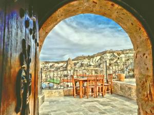 an archway with chairs and a table on a balcony at Grand Cave Suites in Goreme