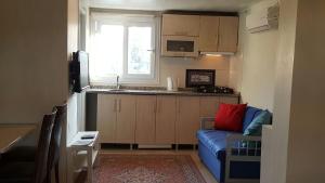 a living room with a blue couch and a kitchen at Ephesus Selcuk Castle View Suites in Selçuk