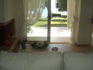a living room with a white couch in front of a door at Villa Anemi in Nea Skioni