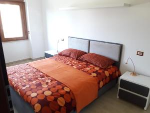 ein Schlafzimmer mit einem großen Bett mit einer orangefarbenen Bettdecke in der Unterkunft Villa del Parco in Perugia