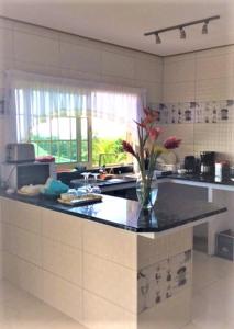 a kitchen with a counter with a vase of flowers on it at Korrine's Cottage HORIZON in Beau Vallon