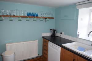 una cucina con un lavello e un piano di lavoro di Ceiros Cottage a Llangammarch Wells Altre 37 foto