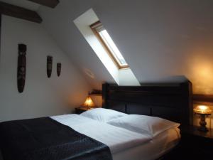a bedroom with a bed with a window and two lamps at Penzion Rozmarýn in Vsetín