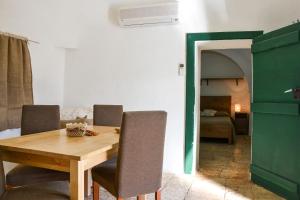 a dining room with a wooden table and chairs at B&B Masseria del Marchese in Castellana Grotte